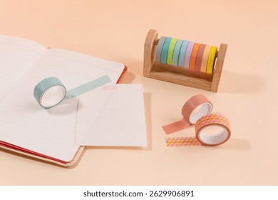Creative workspace setup featuring colorful washi tape, notebook, and decorative paper during bright afternoon light