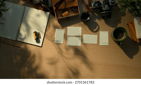 Creative workspace with vintage camera, notebook, and coffee cup in warm morning sunlight.