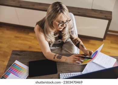 Creative young woman looking thoughtful while working in comfort of her home. - Powered by Shutterstock