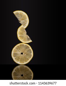 Creatively Balanced Fresh Lemon Fruit Slices On Dark Background. Unusual Photo. Seem To Defy Gravity 