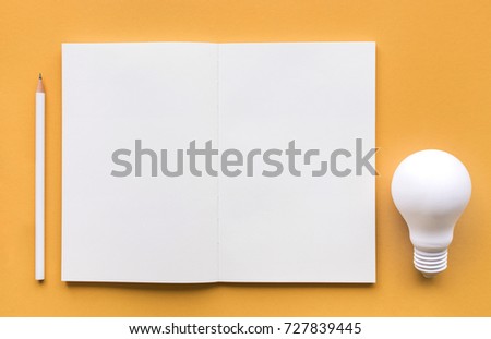 Creativity inspiration,ideas concepts with lightbulb and notepad on pastel color background.Flat lay design.