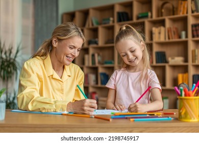 Creativity Lessons For Children. Happy Cute Girl Drawing With Professional Female Teacher At Cabinet, Enjoying Art Classes At Private Preschool Lessons