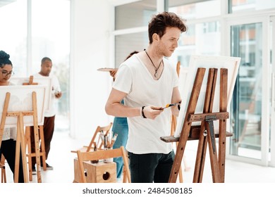 Creativity, man and painting in studio for art, design and canvas in workshop. Male instructor, artist and project in class for artwork, teaching and expertise with inspiration for exhibition - Powered by Shutterstock