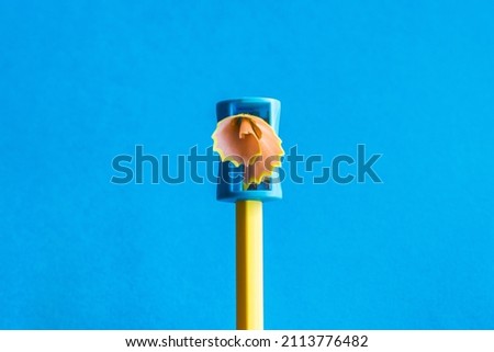 Creativity.
Yellow Pencil That Is Sharpened With A Manual Pencil Sharpener. Blue Background