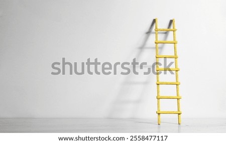 Creativity,solution,innovation,idea,thinking out of the box concept, blue painted wall with ladder of success. Large free copy space,negative space technique