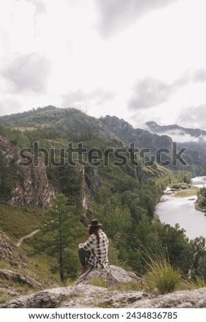 A creator of content for social networks, a young girl photographer shoots summer mountains in Khakassia. Freelance concept, travel, blogger, remote work