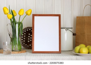 The Creator Of The Cottage Interior Scene. An Empty Frame And Yellow Tulips On The Table.