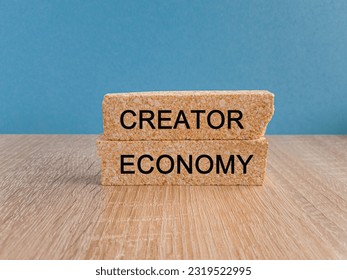 Creator economy symbol. Brick blocks with words Creator economy on beautiful light blue background, copy space. Business and creator economy concept