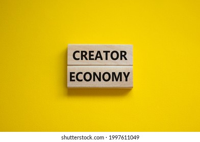 Creator economy symbol. Wooden blocks with words Creator economy on beautiful yellow background, copy space. Business and creator economy concept.