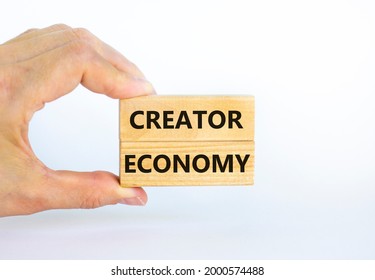 Creator economy symbol. Wooden blocks with words Creator economy on beautiful white background, copy space. Businessman hand. Business and creator economy concept.