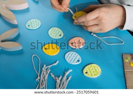 Creator is using white air dry clay for making decor to EASTER holiday. Creating hobby recreation activity that involves fingers. DIY crafting