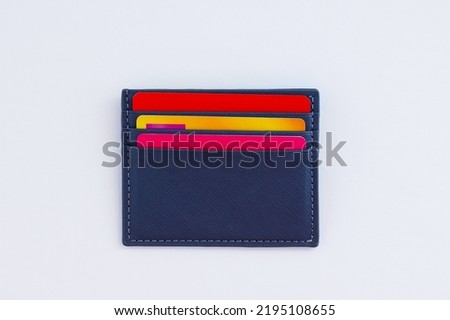 Credit bank cards in a gray business card holder. White background.