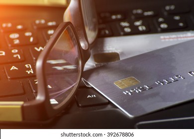 Credit card and ball pen on a laptop
