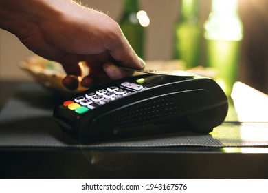 Credit card machine for money transaction. Close up of male hold in hand wireless modern bank payment terminal to process acquire credit card payments black card. Credit card through pos terminal - Shutterstock ID 1943167576