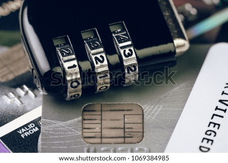 Credit card online payment data security concept, combination code lock pad on pile of credit cards, e-commerce safety encode to transmit data.