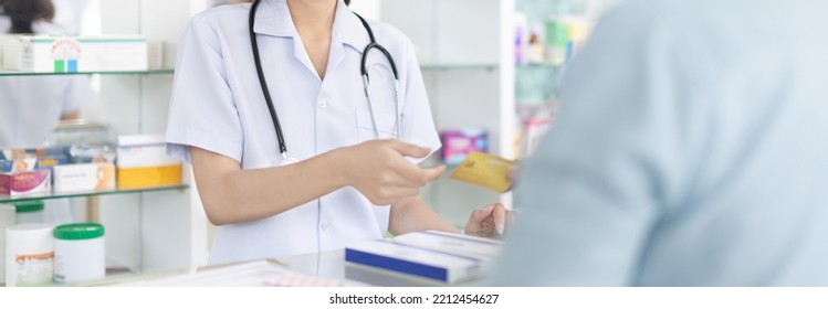 Credit Card Payment, Male Patient Pays By Credit Card To A Pharmacist In A Pharmacy, Get Service At A Community Pharmacy , Pharmacist Or Cashier Scanning Medicinal Products At Checkout.