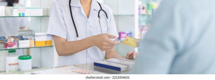 Credit Card Payment, Male Patient Pays By Credit Card To A Pharmacist In A Pharmacy, Get Service At A Community Pharmacy , Pharmacist Or Cashier Scanning Medicinal Products At Checkout.