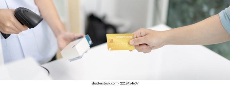 Credit Card Payment, Male Patient Pays By Credit Card To A Pharmacist In A Pharmacy, Get Service At A Community Pharmacy , Pharmacist Or Cashier Scanning Medicinal Products At Checkout.