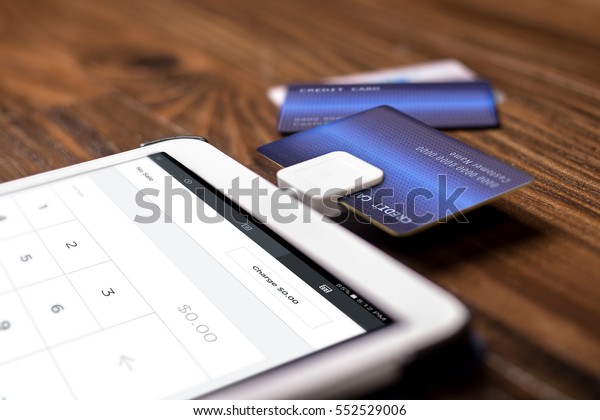 Credit card payment\
on a swipe or chip reader app on a tablet used by small or online\
businesses.  The electronic device is used as a modern cash\
register or for banking.