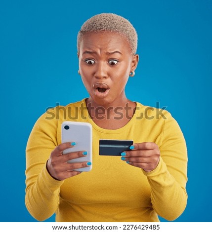Credit card, phone and woman shocked for online shopping mistake, transaction fail or debt isolated on blue background. Wow, surprise and stress person for fintech payment mistake on mobile in studio