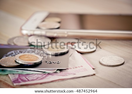 Credit card,  plastic card, money,bank note, and coins put on smartphone . Electronic money and ewallet concept, new payable in Fintech era.
