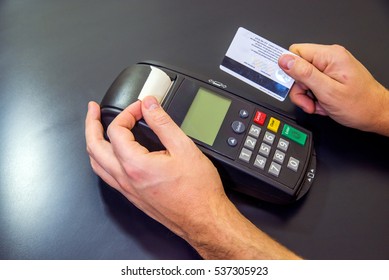 Credit Card Reader Machine On White Background. Card Machine Or Pos Terminal With Inserted Blank White Credit Card Isolated On White Background. Hand And Fingers Entering Pin With A Hand Held Pin Pad.