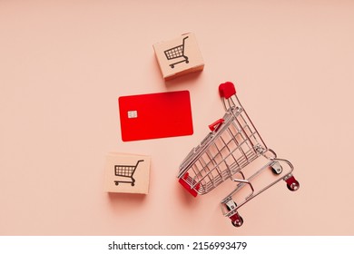 Credit card with shopping cart and delivery boxes on pink background. Shopping and delivery concept. - Powered by Shutterstock