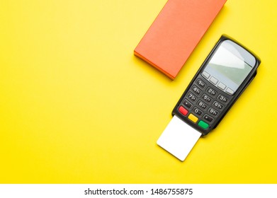 Credit Card Terminal And Gift Box On Yellow Background. Close Up Of Merchant  Payment Device, Card Machine.