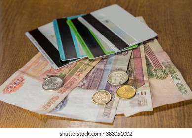 Credit Cards And Cash Lying On A Wooden Table