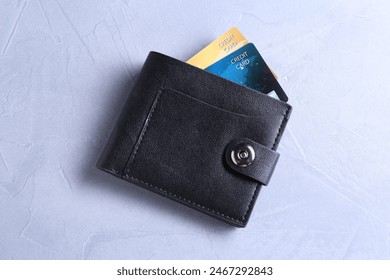 Credit cards in leather wallet on grey textured table, top view