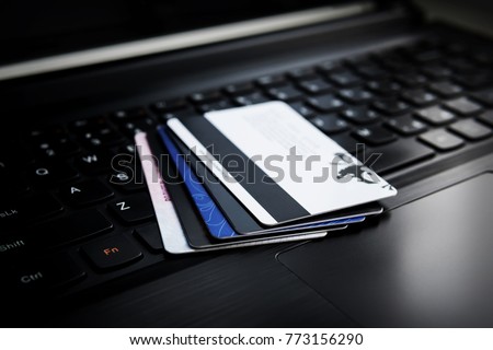 Credit cards on a laptop. Several credit and discount cards are on the keyboard of a black laptop. Online payment. Cashless settlement. Buying goods via the Internet. transfer of money.