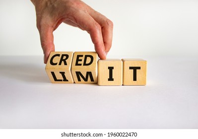 Credit limit symbol. Businessman turns wooden cubes and changes the word 'limit' to 'credit'. Beautiful white table, white background, copy space. Business and credit limit concept.