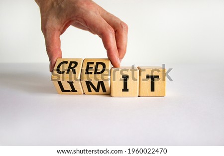 Credit limit symbol. Businessman turns wooden cubes and changes the word 'limit' to 'credit'. Beautiful white table, white background, copy space. Business and credit limit concept.