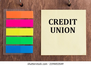 Credit Union Text On A Yellow Card That Sits On A Wooden Background