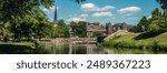 A creek against a blue sky and church steeple leads to a downtown area of suburban Maryland in Frederick County