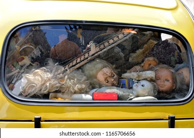 Creepy Abandoned Children's Dolls Lie Behind The Dirty Glass Of A Car