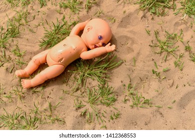 Creepy  Baby Doll Lying On The Sand