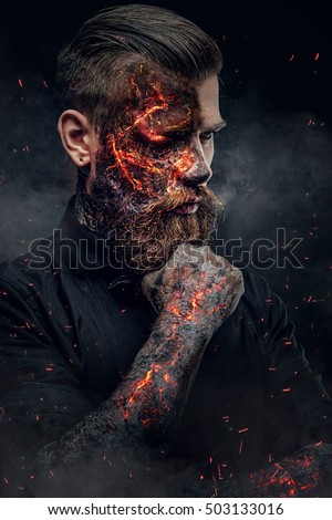 Creepy demonic male in a fire sparks and smoke.