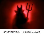 Creepy Devil silhouette from hell in the mist with backlit.