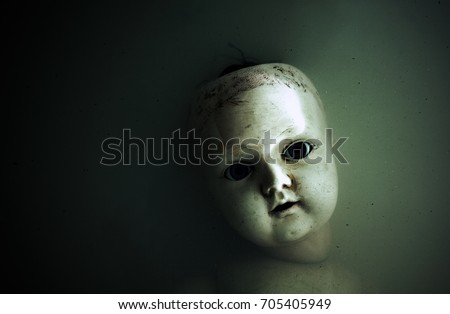 Creepy doll face in dark dirty water 