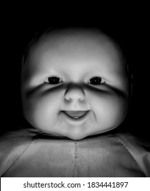 Creepy doll face. It seems like character of horror movie. Halloween concept. Black and white shot, low-key lighting. Isolated on black.