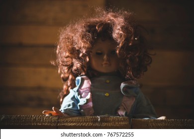 Creepy Doll With One Open Eye And Curly Hair On The Attic