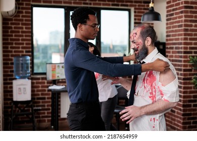 Creepy Eerie Zombie Talking To Man At Workplace, Macabre Cruel Monster Corpse In Business Office Acting Aggressive And Dangerous. Scary Undead Devil With Bloody Wounds In Company Space.