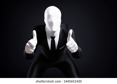 Creepy Faceless Guy In Tight Business Suit Showing Approval With Thumbs Up Over Black Background