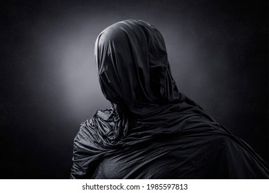 Creepy figure over dark misty background - Shutterstock ID 1985597813