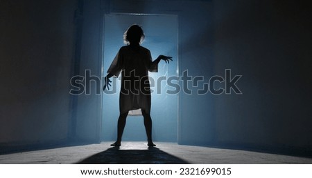 Creepy girl in white shirt scarily running in hallway with unnatural steps. Scary lunatic in old house - halloween costume party 