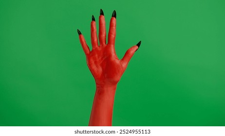 Creepy halloween devil monster hand in red paint with black nails shows open palm, isolated on chroma key green screen background, workspace mockup. - Powered by Shutterstock