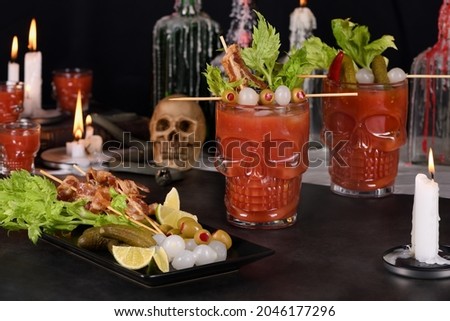 Creepy Halloween party. Michelada the Mexican Bloody Mary. Prepared with tomato juice, tequila, hot sauce, served with ice in a beer glass with bacon garnished with celery, olive, and pickled onions