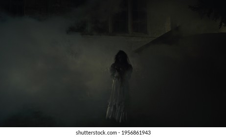 Creepy lone bride near misty medieval castle