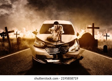 Creepy Male Ghost Sitting On The Hood Of Broken Car With Burning Grave Background At Night Time